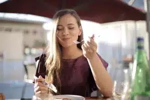 Young woman practicing the 10 core principles of intuitive eating.