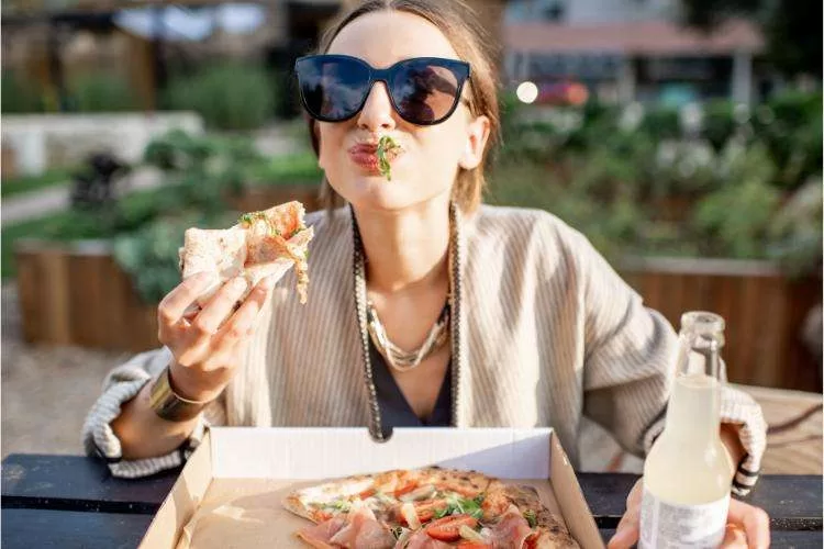 Woman overcoming her fear of eating in public (Deipnophobia) by eating pizza.