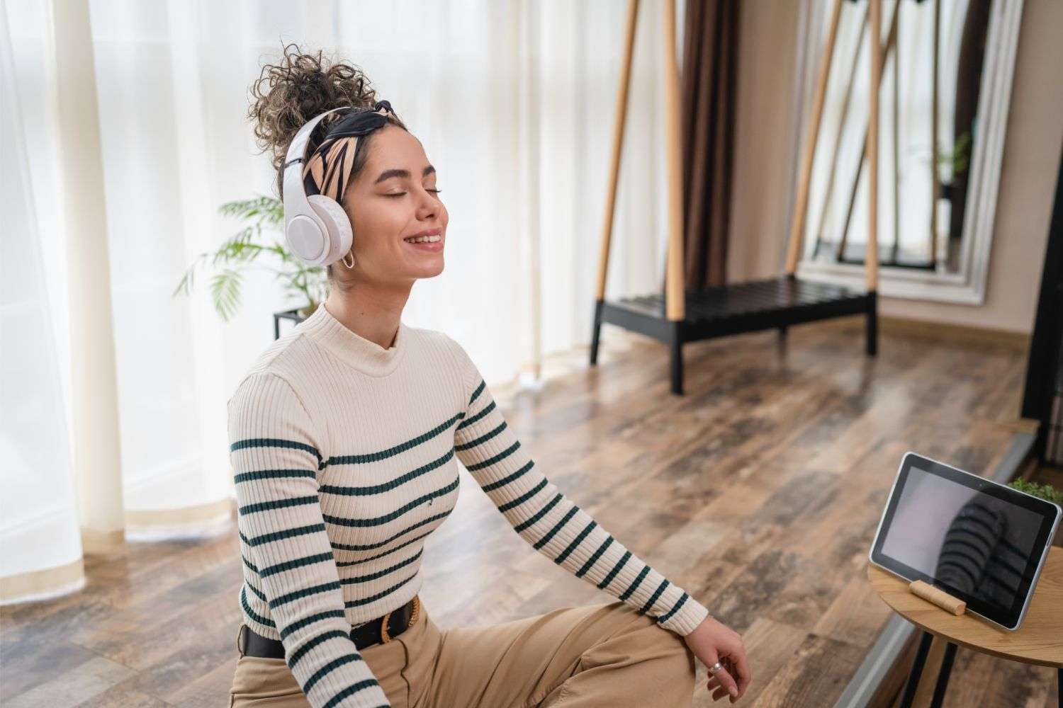 Woman listening to headphones and practicing self care.