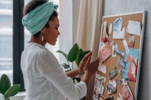 Woman putting up pictures to create a vision board.