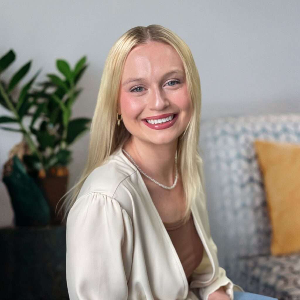 Professional headshot of McKenzie Korhorn in a white sweater.