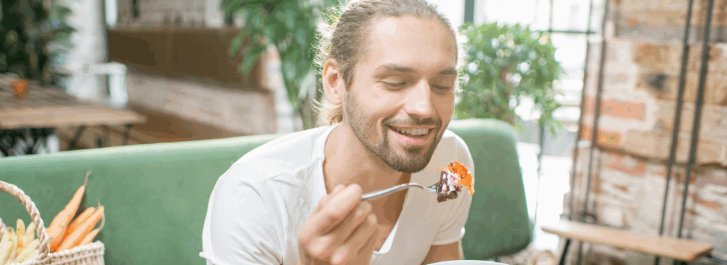 A man calmly enjoying a meal, eating mindfully and listening to his body’s hunger and fullness cues.