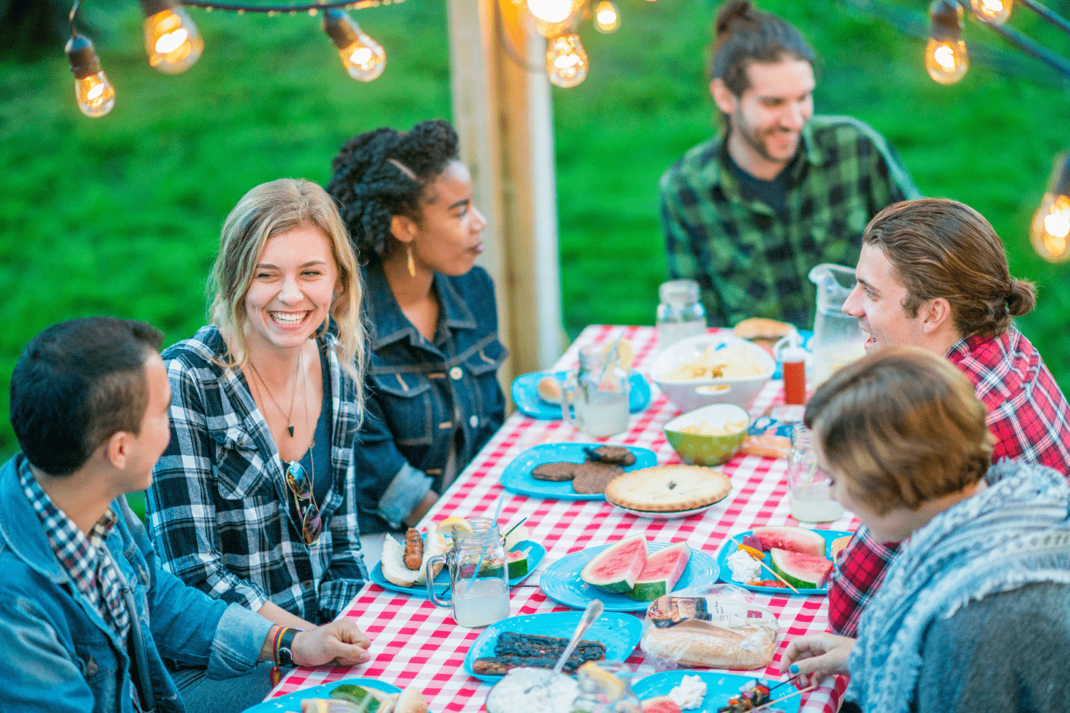 Friends at a summer barbecue eating burgers and fruit, highlighting challenges of food-centered social events during eating disorder recovery.