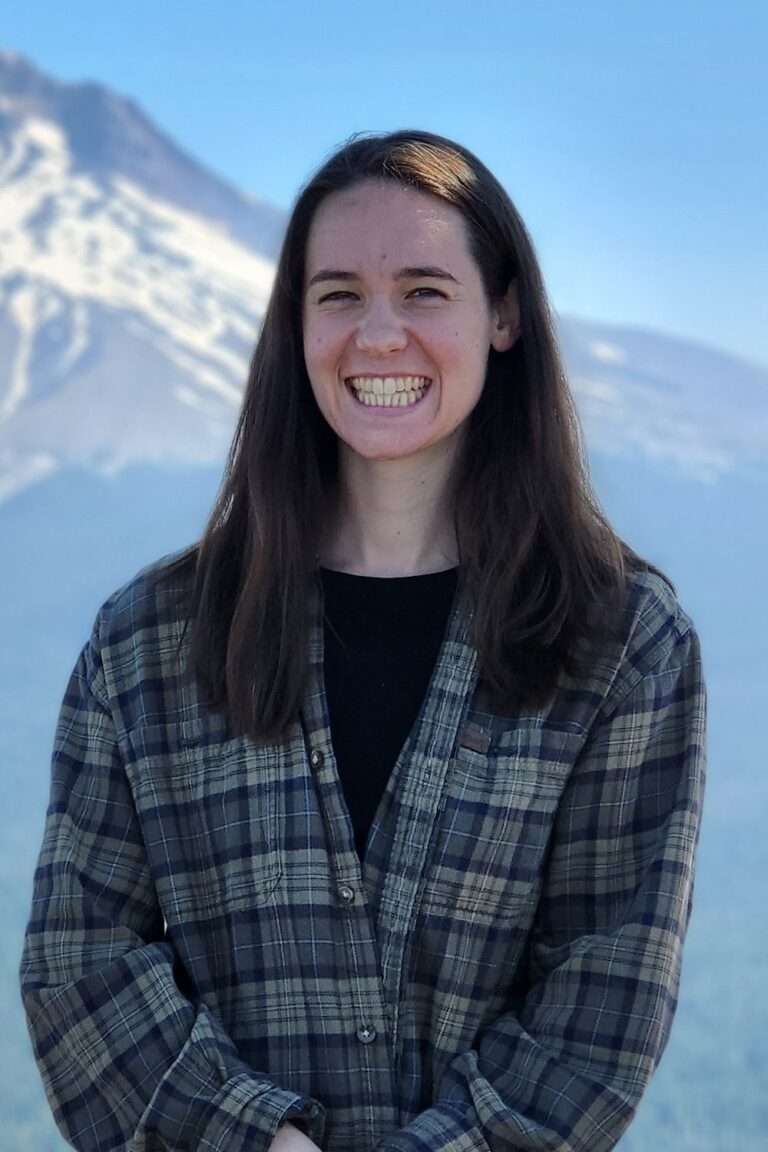 Bri Gulker, registered dietitian and certified eating disorder specialist, standing in front of mountains.