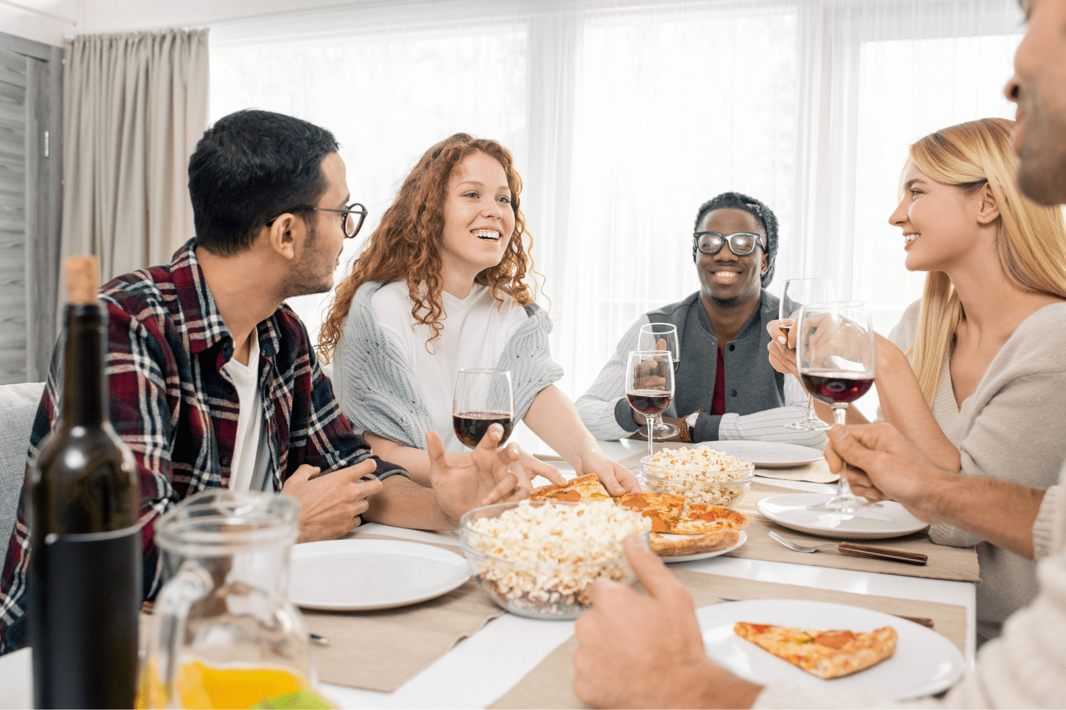 A friend group enjoying a meal together while being mindful of what not to say to support someone with an eating disorder.